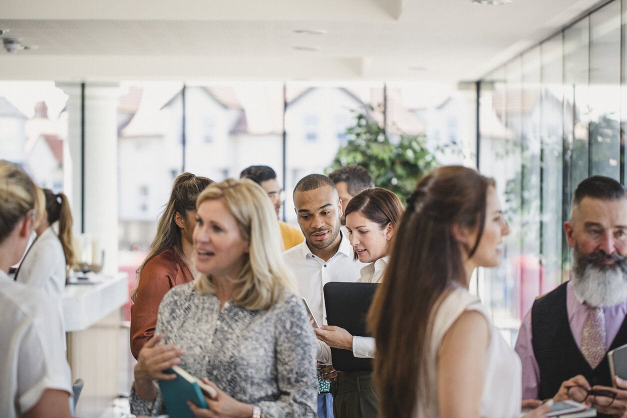 Professionals engaging in networking and discussion at a conference.