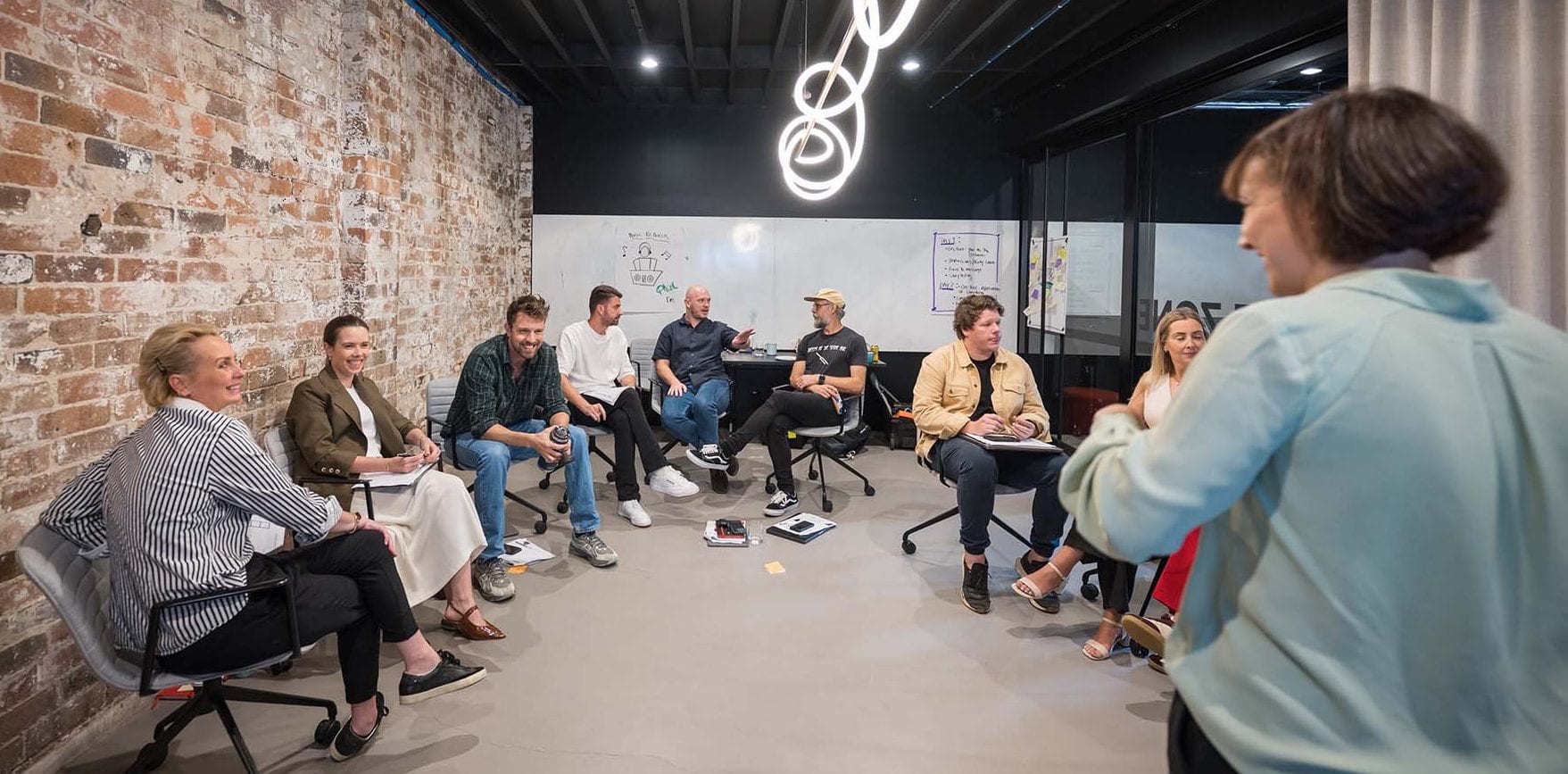 Australian professionals in a team workshop discussing collaboration and leadership.